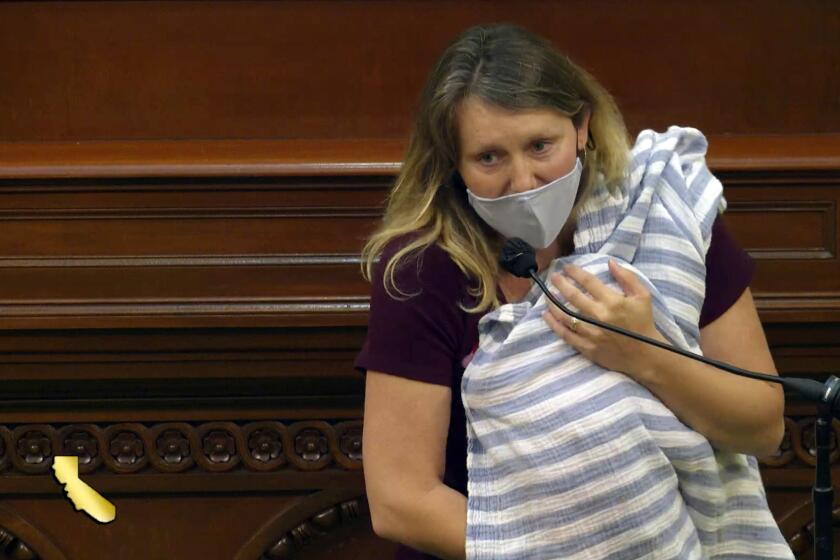 In this still image from California State Assembly video, Assemblywoman Buffy Wicks, a Democrat from Oakland, addresses lawmakers on a housing bill while holding her one-month-old daughter Elly in her arms during the final hours of the California legislative session Monday, Aug. 31, 2020, in Sacramento, Calif. Wicks requested permission from legislative leaders to vote remotely during the coronavirus pandemic because of her newborn but was denied. (California State Assembly via AP)