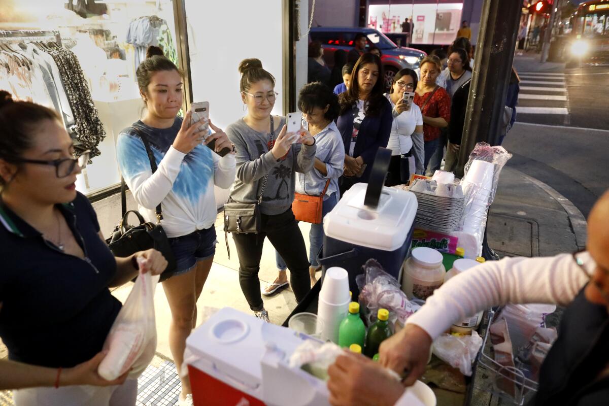 Customers wait in line for Andres Santos' esquites