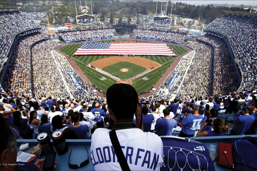 A fan looks on during the pregame ceremony at Dodger Stadium for the Dodgers' home opener against the San Francisco Giants.