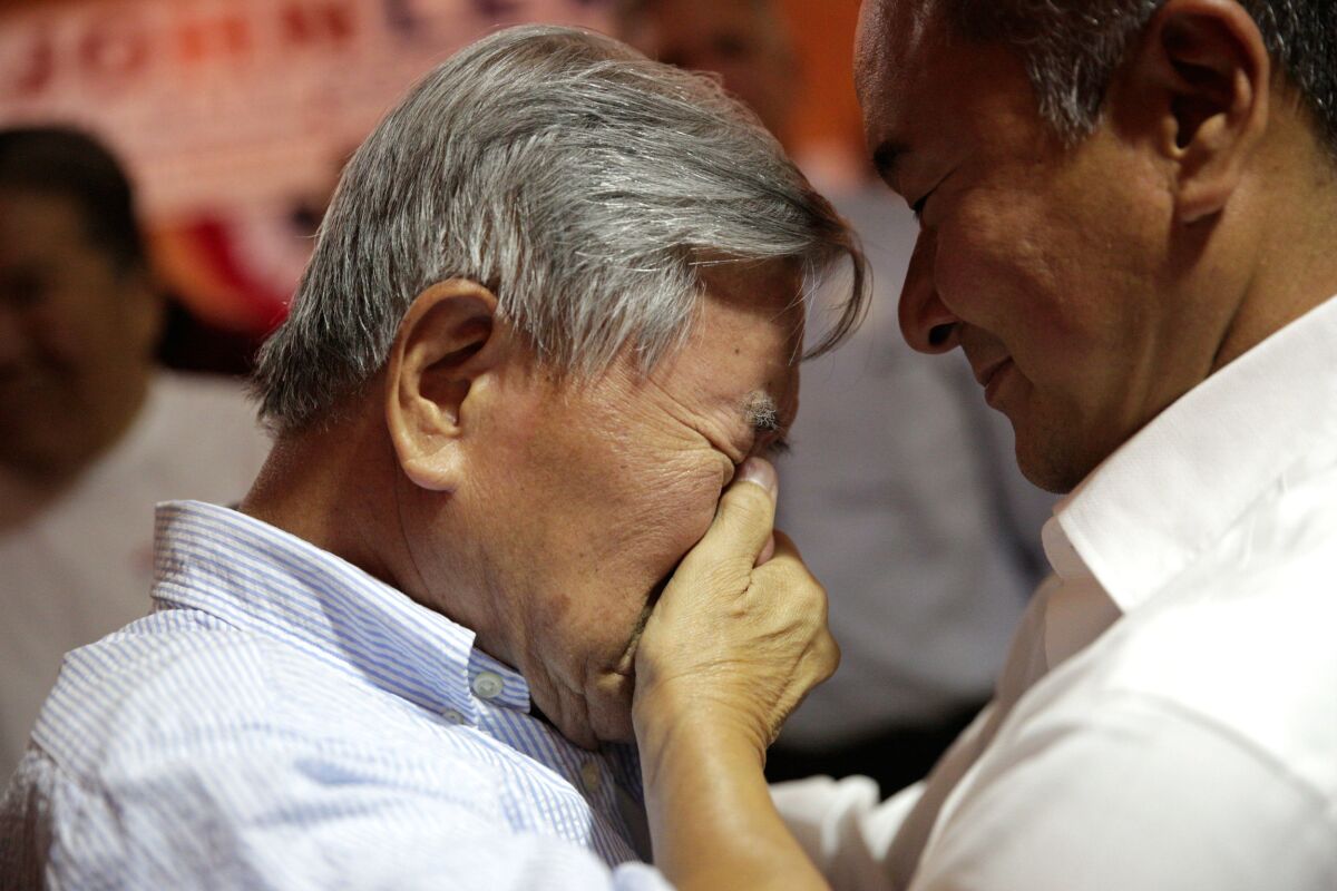 John Lee's father, Young Lee, is overcome with emotion as he celebrates with his son early Wednesday.