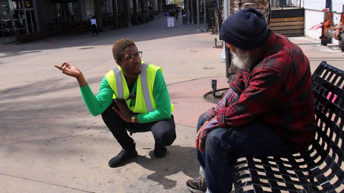 La Quentan McGuire, ambassador team leader, talks with a homeless man in March and guides him to facilities that can help him in the Burbank downtown plaza area on East Palm Avenue. The ambassador program is one of the ways Burbank is addressing the city's homelessness issue.