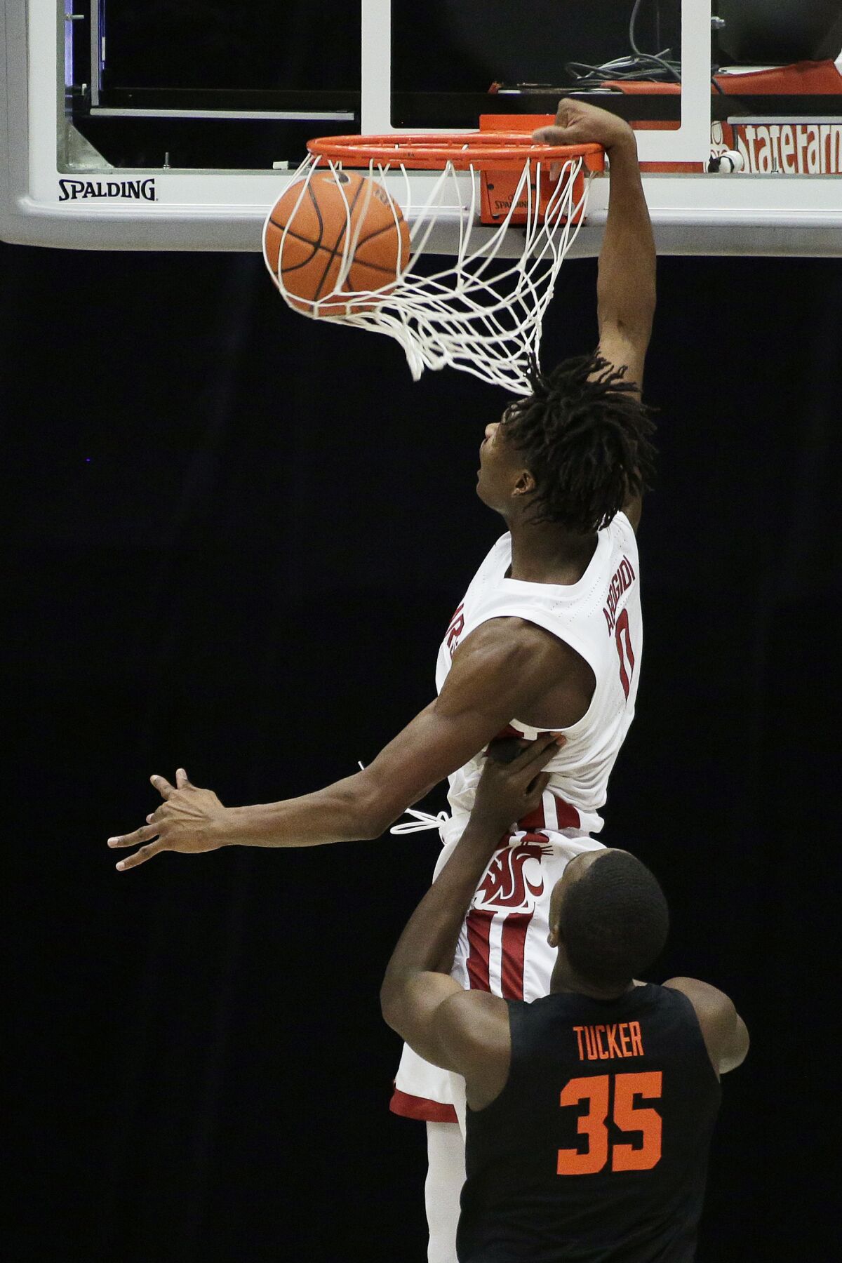 Washington State center Efe Abogidi (0) dunks in front of Oregon State forward Dearon Tucker (35) during the second half of an NCAA college basketball game in Pullman, Wash., Wednesday, Dec. 2, 2020. Washington State won 59-55. (AP Photo/Young Kwak)