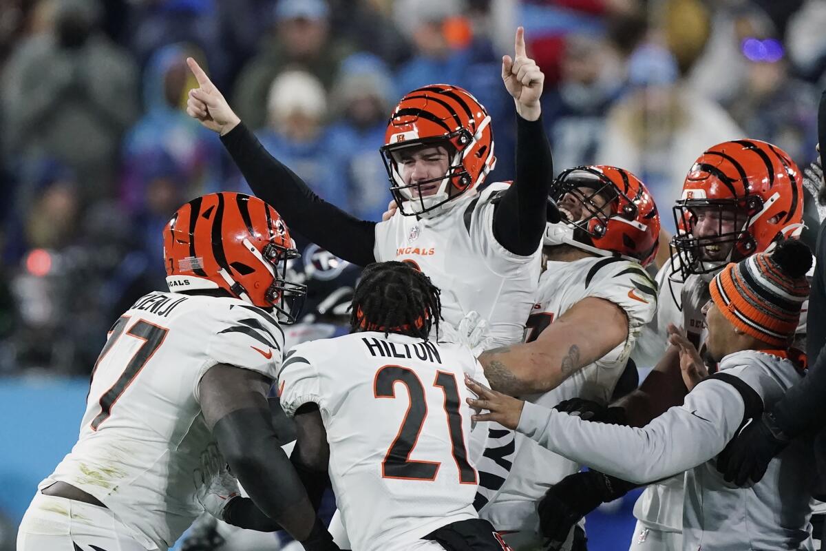 Evan McPherson, top center, celebrates with Bengals teammates after his field goal beat the Tennessee Titans in the playoffs.