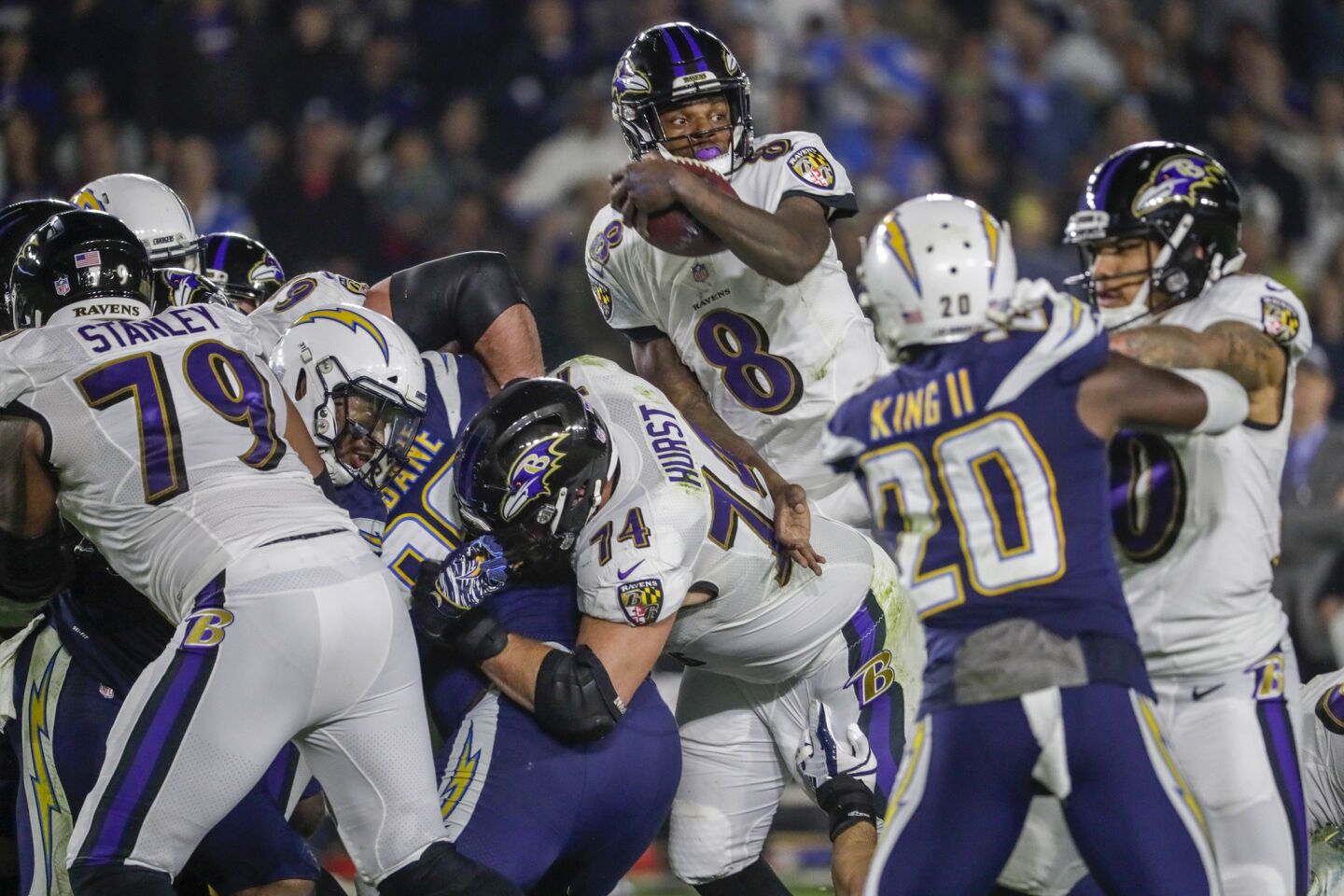 Ravens quarterback Lamar Jackson looks for the first down marker as he jumps over the pile, gaining a first down on a fourth down play in the second quarter at StubHub Center.