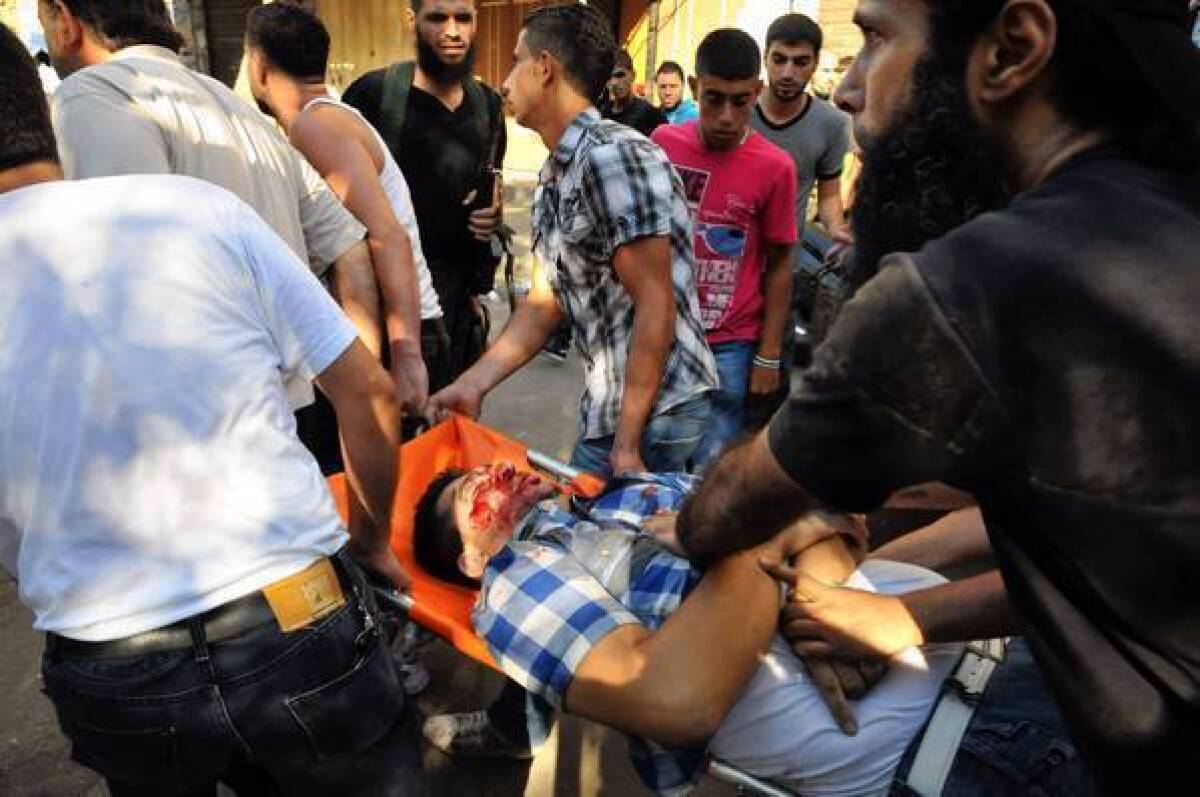 An injured man is carried away in Tripoli, Lebanon, after clashes between opponents and supporters of Syrian President Bashar Assad.