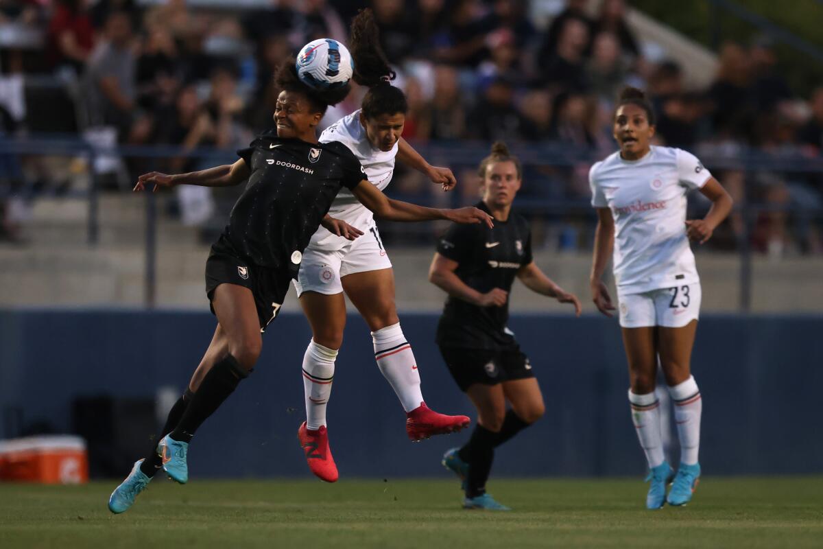 Angel City FC's Simone Charley and the Portland Thorns' Raquel Rodríguez head the ball. 