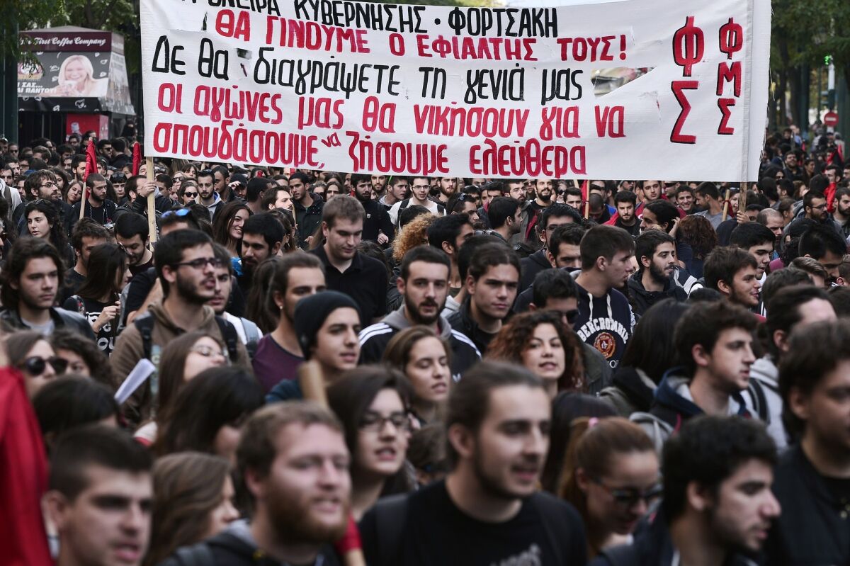 High school and universities students hold a banner reading "You won't delete our generation -- our struggle will win and we will study and live freely" during a march in central Athens on Nov. 6, 2014, to protest a teacher shortage and layoffs of universities' administrative staff.