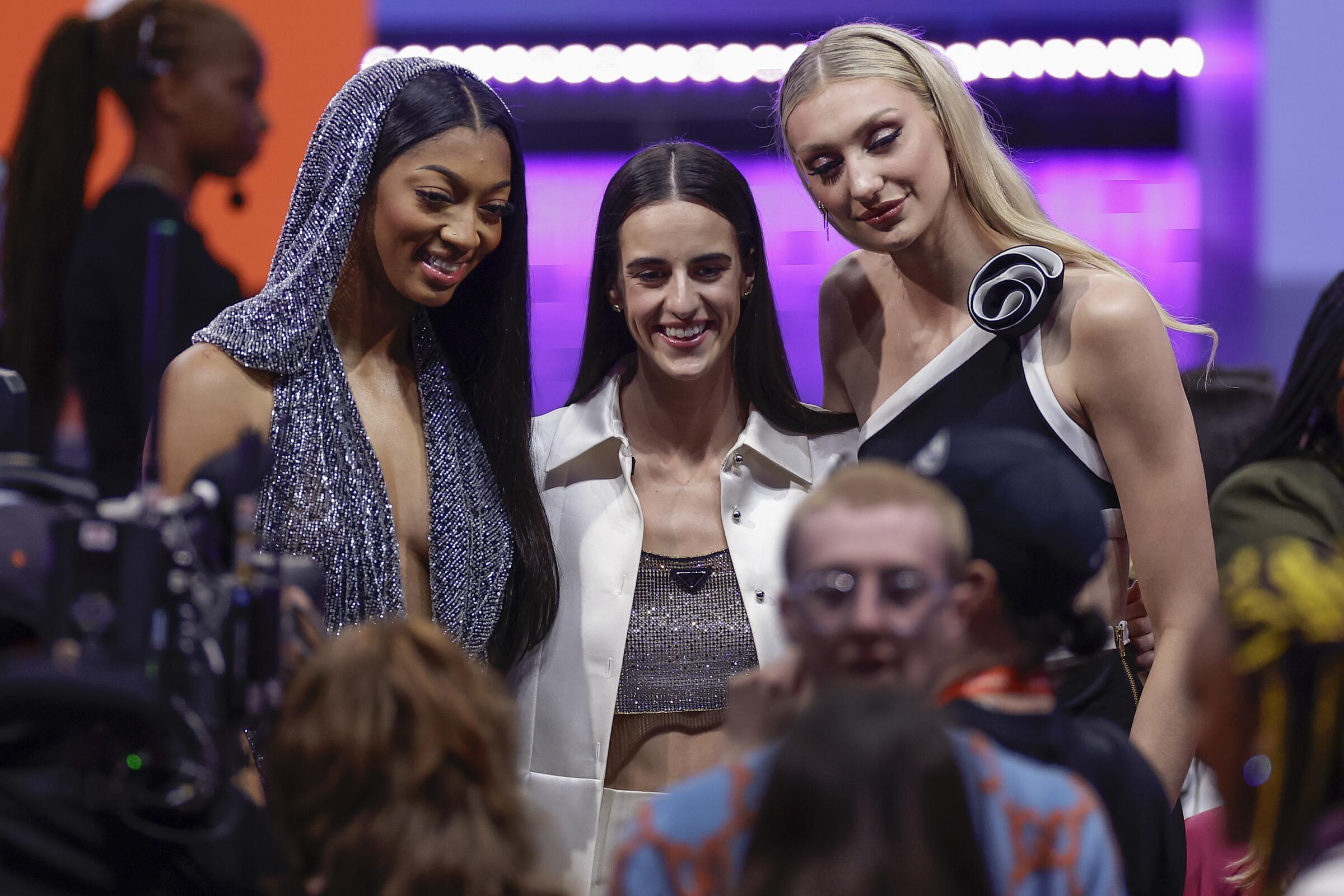 WNBA rookie stars Angel Reese, left, Caitlin Clark and Cameron Brink stand together at the WNBA draft.