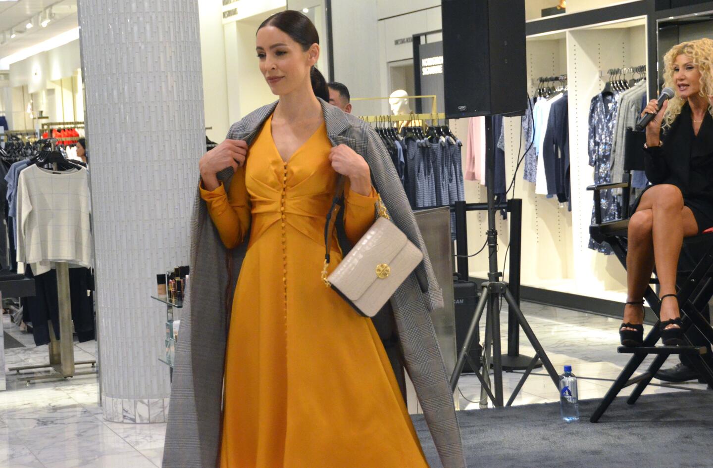 A model wears a dress by Jonathan Simkhai and a plaid coat by Sanctuary.