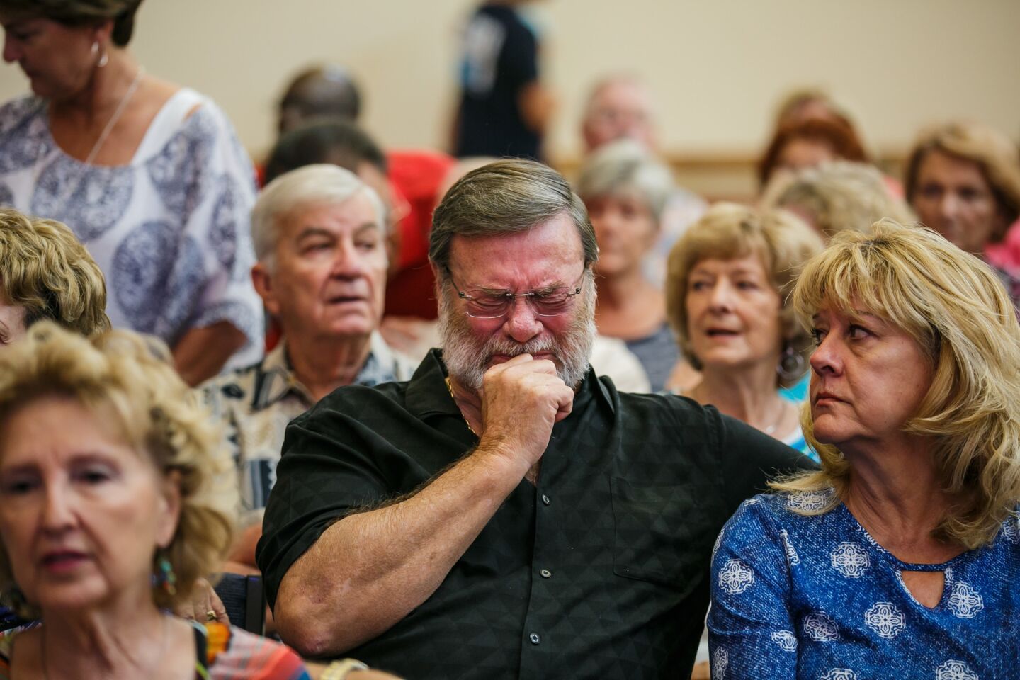 Wayne Christopher, center, weeps as his wife, Helen, looks on during a Sunday service at First United Methodist Church in Dickinson, Texas.