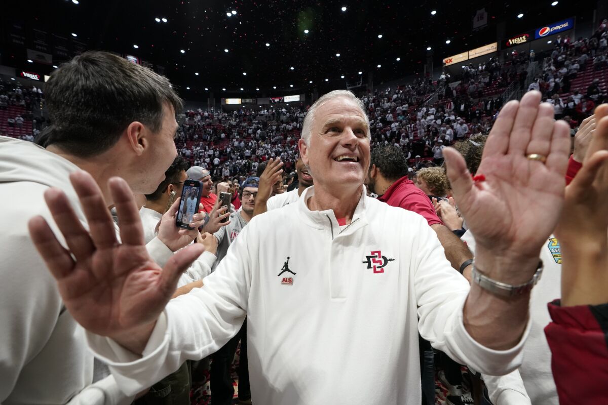 FILE - San Diego State head coach Brian Dutcher reacts with fans after San Diego State defeated Wyoming in an NCAA college basketball game to win the Mountain West Conference on March 4, 2023, in San Diego. Dutcher will always be known for recruiting the Fab Five and spending all those years at Steve Fisher's side, winning the NCAA title at Michigan in 1989 and building San Diego State into a West Coast power. Dutcher now has his first two NCAA Tournament wins as a head coach. (AP Photo/Gregory Bull, File)