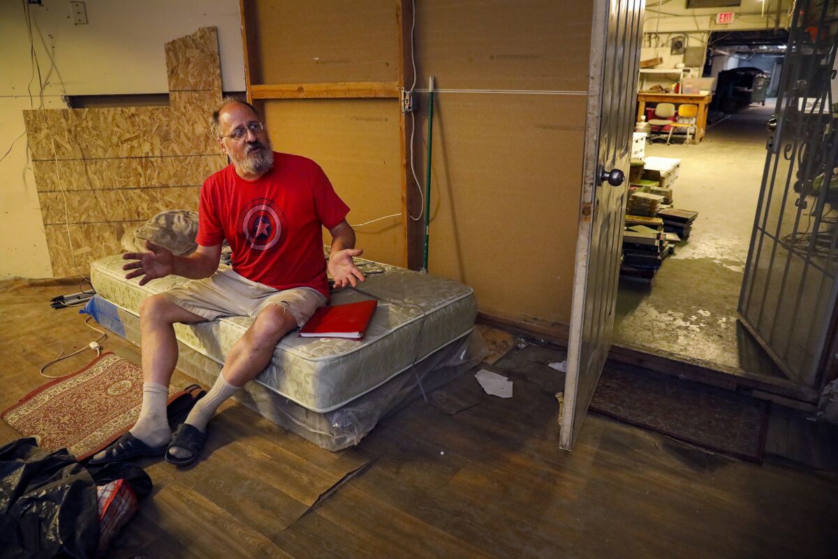 Mark Miner sits on the bed of his basement apartment below the C Street Inn. 