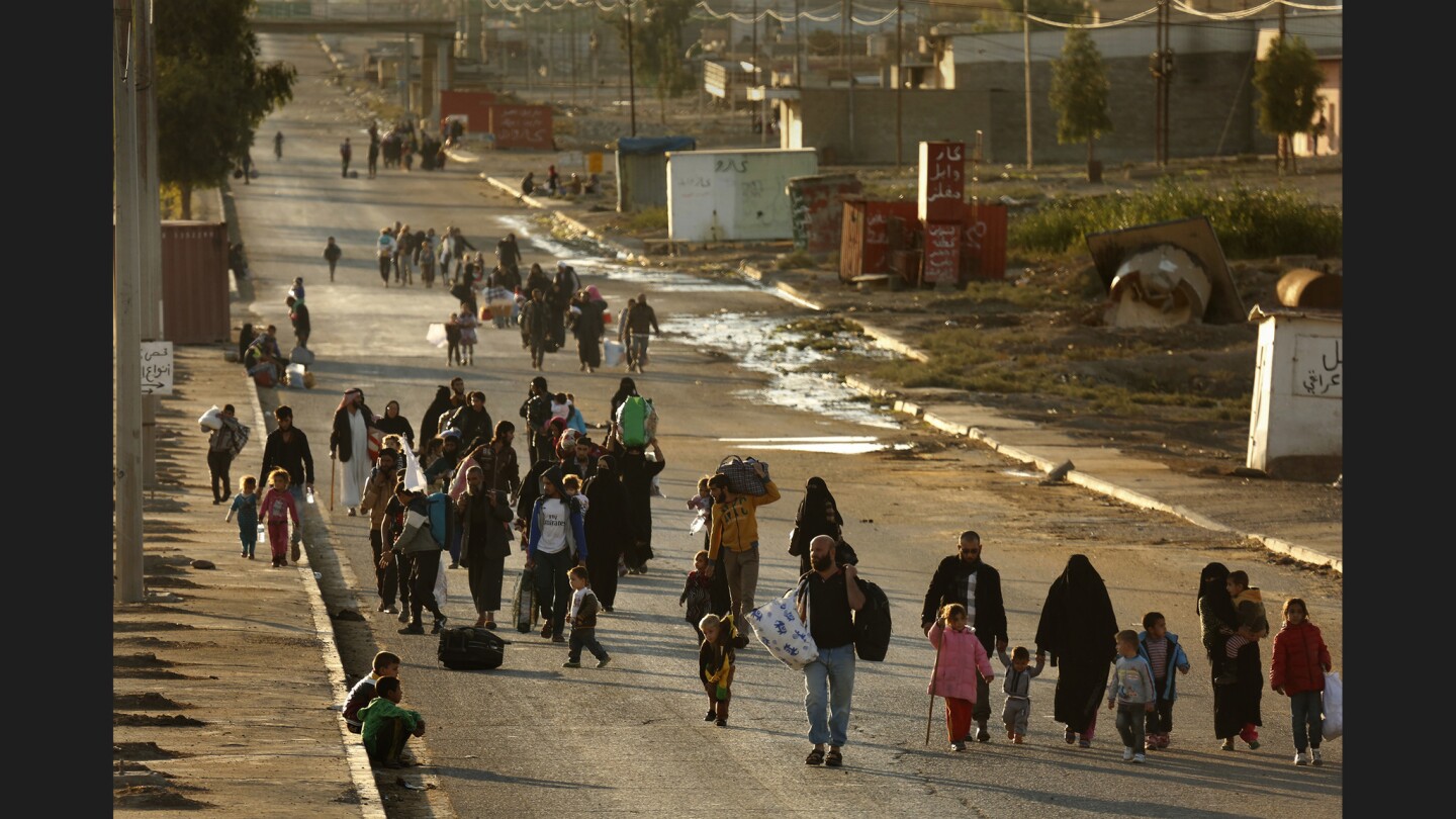 Several hundred civilians make their way through Gogjali, Iraq, after the Iraqi army retook control of the district from Islamic State militants.