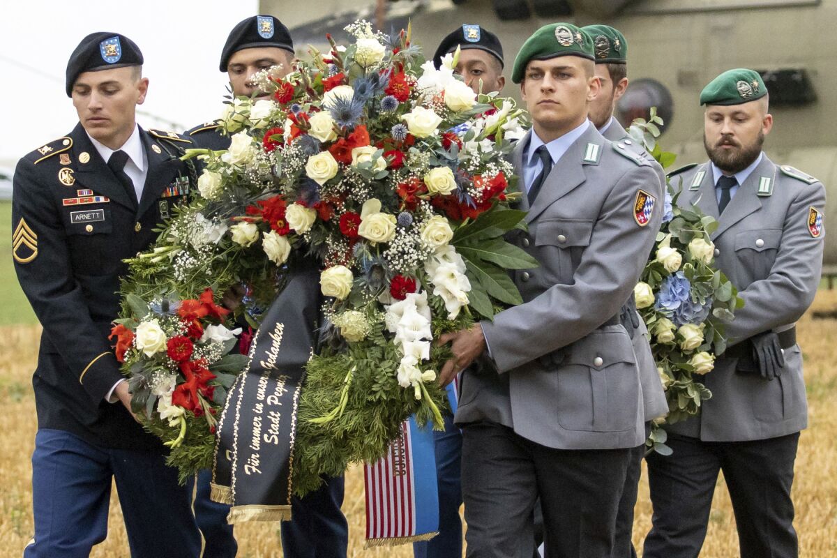 U.S. and German soldiers carry a wreath from a Chinook transport helicopter during a commemoration of a helicopter crash in Pegnitz, Germany, Wednesday, Aug. 18, 2021. On Aug. 18, 1971, a U.S. Army Chinook helicopter crashed near Pegnitz. 37 soldiers were killed. It is the worst accident of the US Army since the Second World War. (Daniel Karmann/dpa via AP)