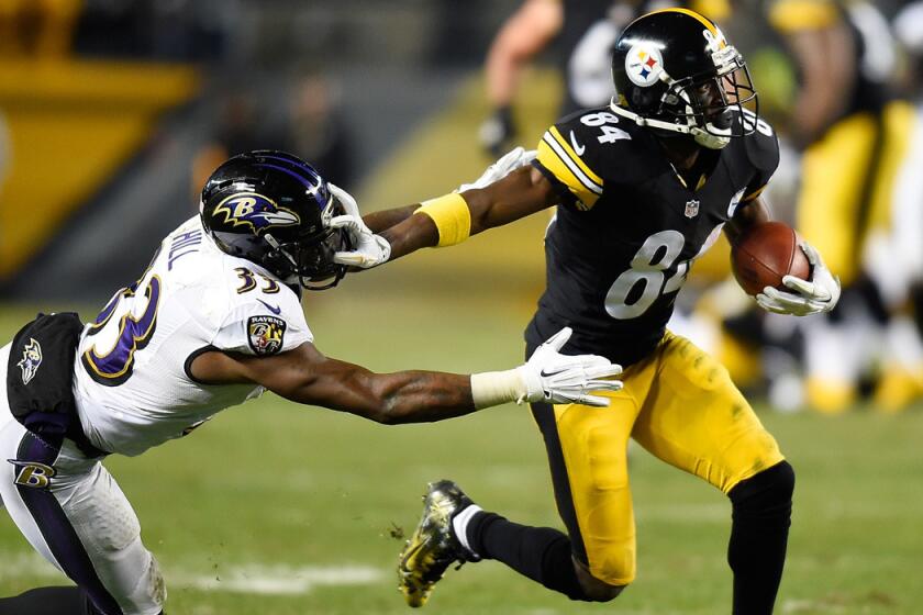 Steelers wide receiver Antonio Brown breaks a tackle by Ravens defensive back Will Hill during a 54-yard touchdown pass play in the fourth quarter Sunday night in Pittsburgh.