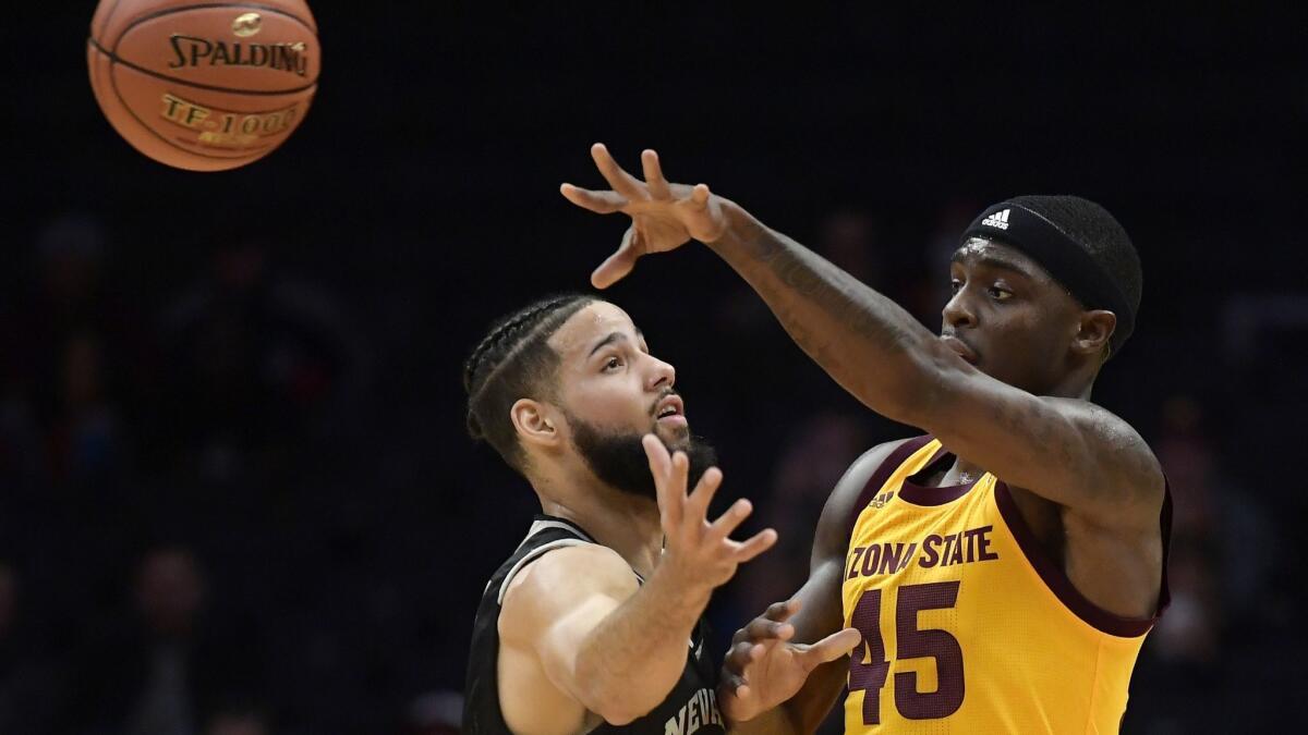 Arizona State forward Zylan Cheatham, right, passes the ball while under pressure from Nevada forward Caleb Martin during the first half of the Basketball Hall of Fame on Classic Friday at Staples Center.
