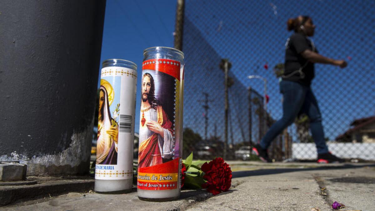 Un modesto altar para un hombre asesinado a balazos el sábado se encuentra en la intersección de la 81st y Hoover Street en el sur de Los Angeles el lunes.