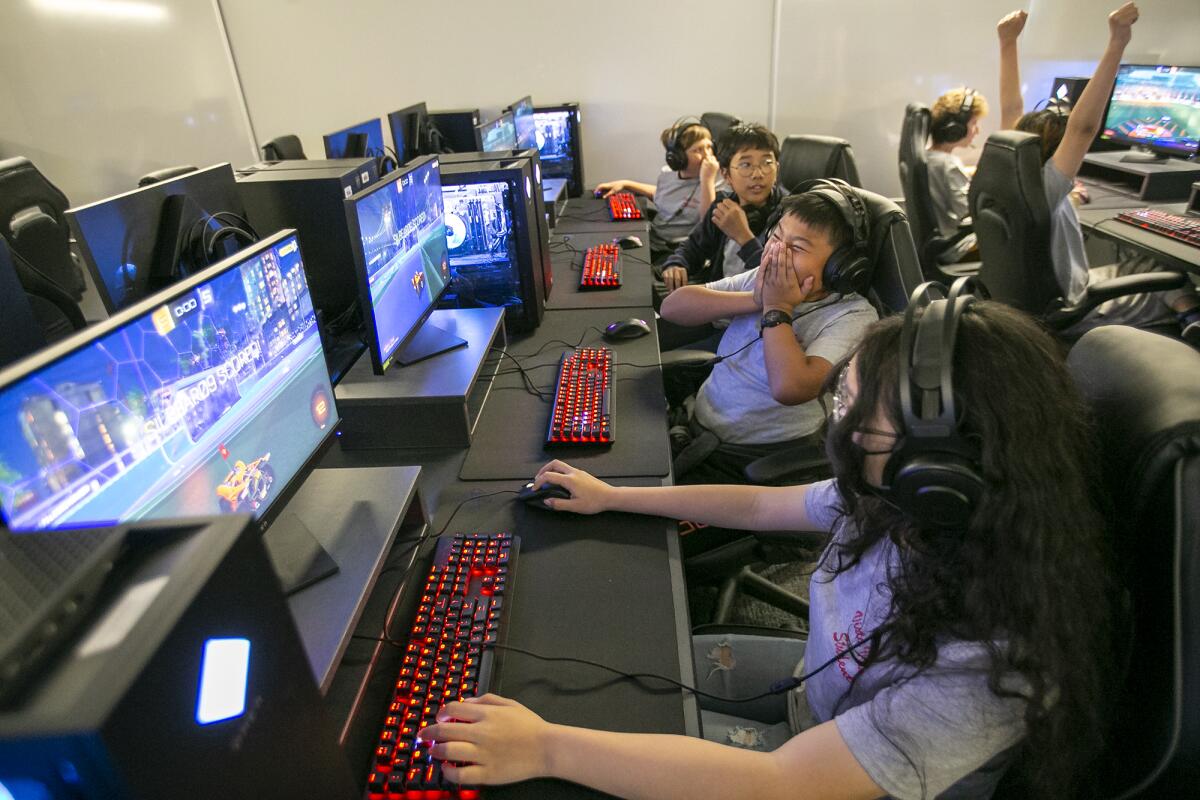 Catt Duong, 12, right, Nathan Hou, 12, center and other students play Rocket League on Thursday.