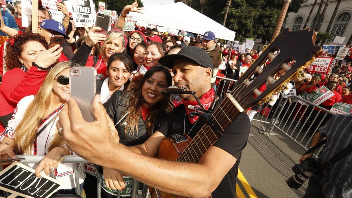 Rage Against the Machine's Tom Morello takes a selfie with teachers as thousands of educators with United Teachers Los Angeles rallied on the fifth day of the strike in Grand Park.