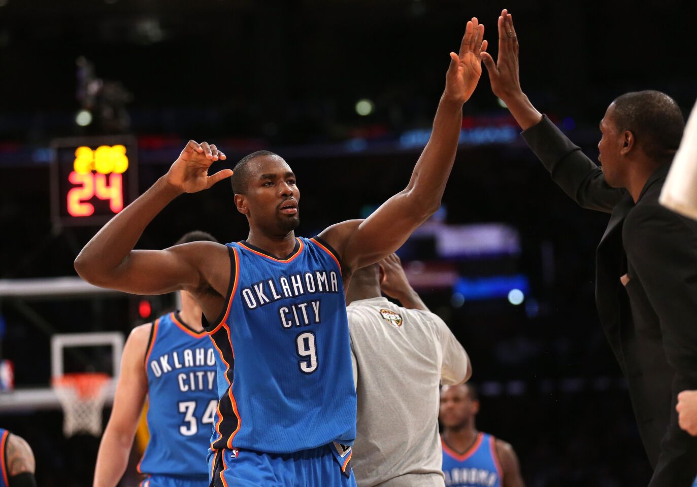Thunder power forward Serge Ibaka is greeted with a high five by injured teammate Kevin Durant in the fourth quarter of the Thunder's win over the Lakers.
