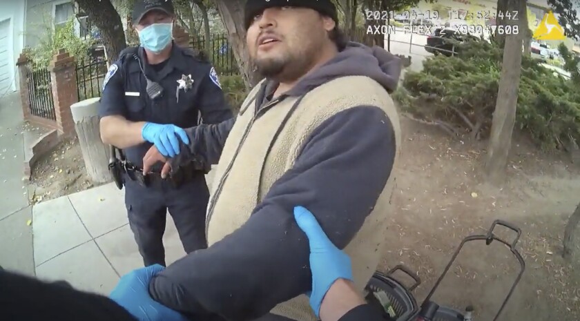 Police officers grip Mario Gonzalez by the arms in an image from video