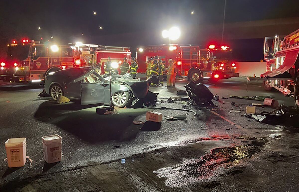Firefighters at the scene of a fatal accident involving a Tesla and a firetruck 