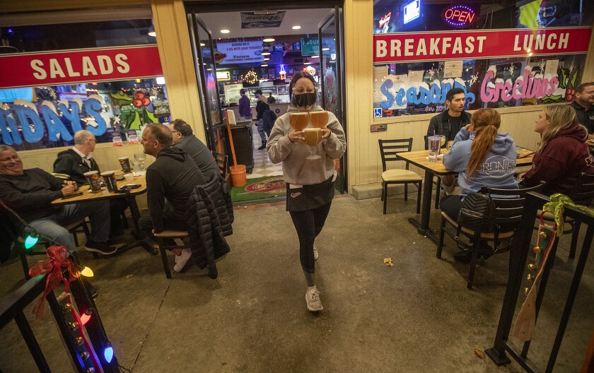 Server carrying beers at eatery