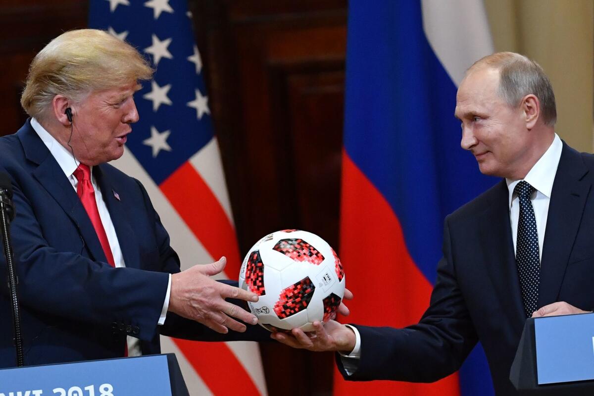 Russian President Vladimir Putin hands a World Cup ball to President Trump during their news conference in Helsinki, Finland, on July 16.