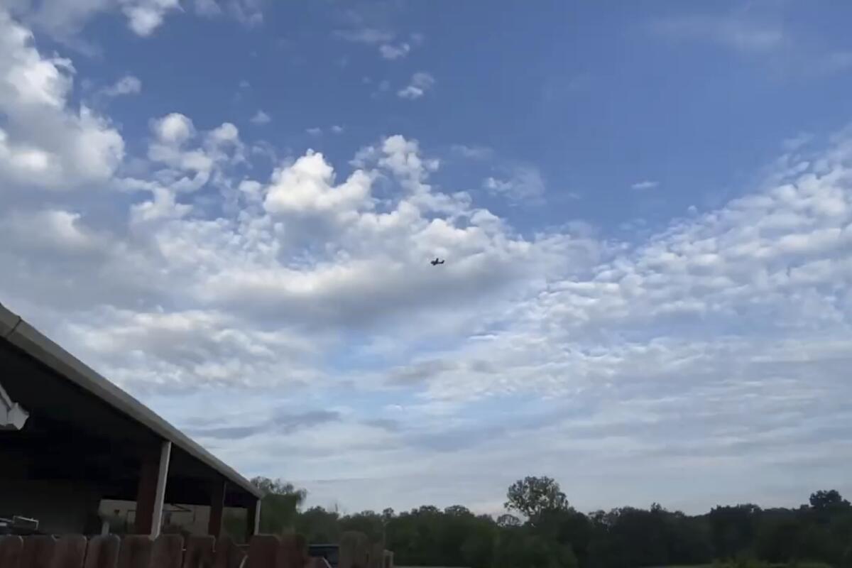 A small airplane circles over Tupelo, Miss., among clouds.