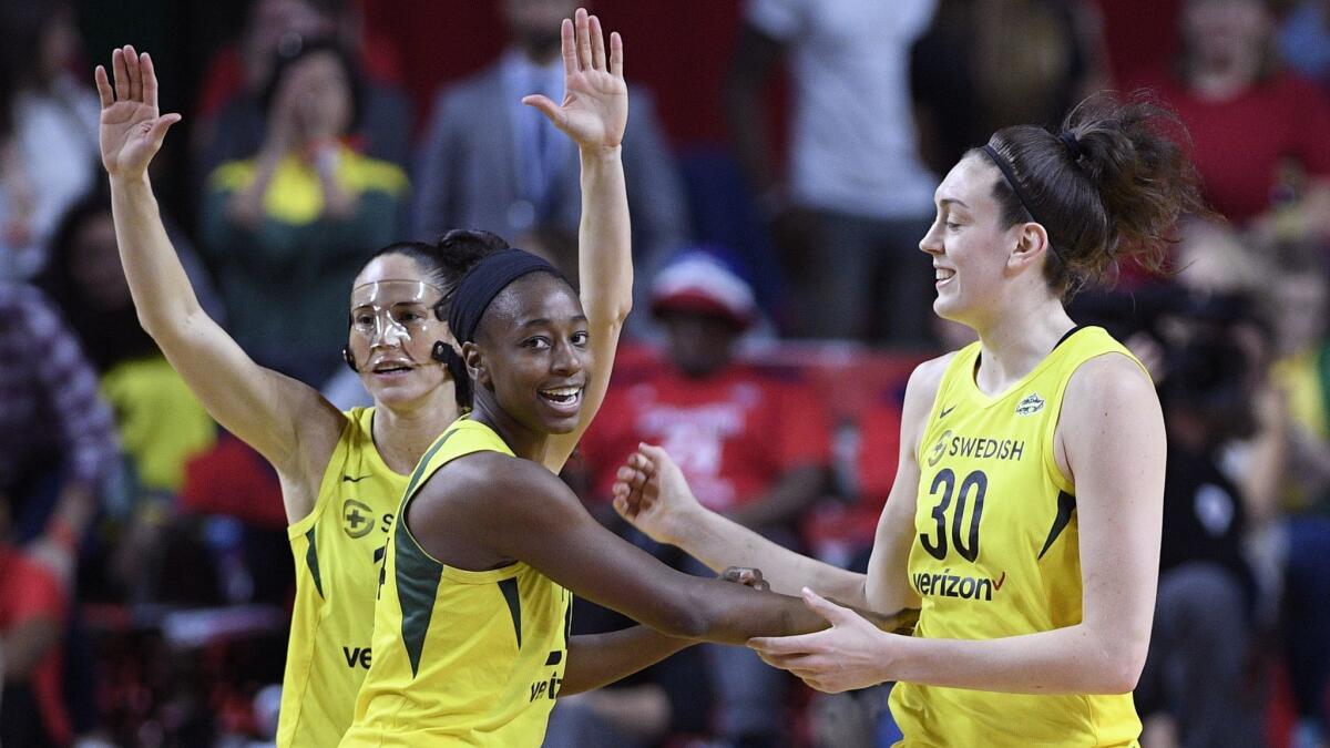 Seattle Storm guard Sue Bird, back left, Jewell Loyd, center, and Breanna Stewart (30) react during the first half of Game 3 of the WNBA finals against the Washington Mystics.