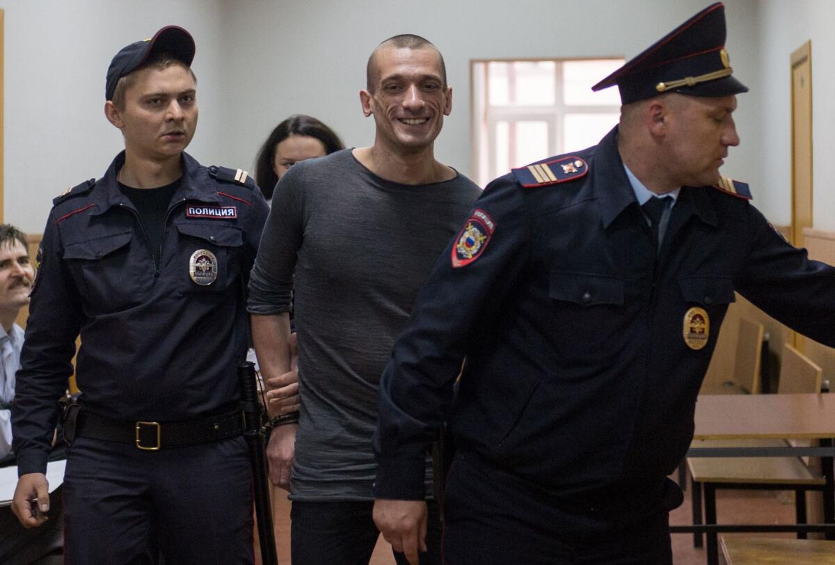 Russian performance artist Pyotr Pavlensky is escorted in a court building before a hearing in Moscow on Wednesday.