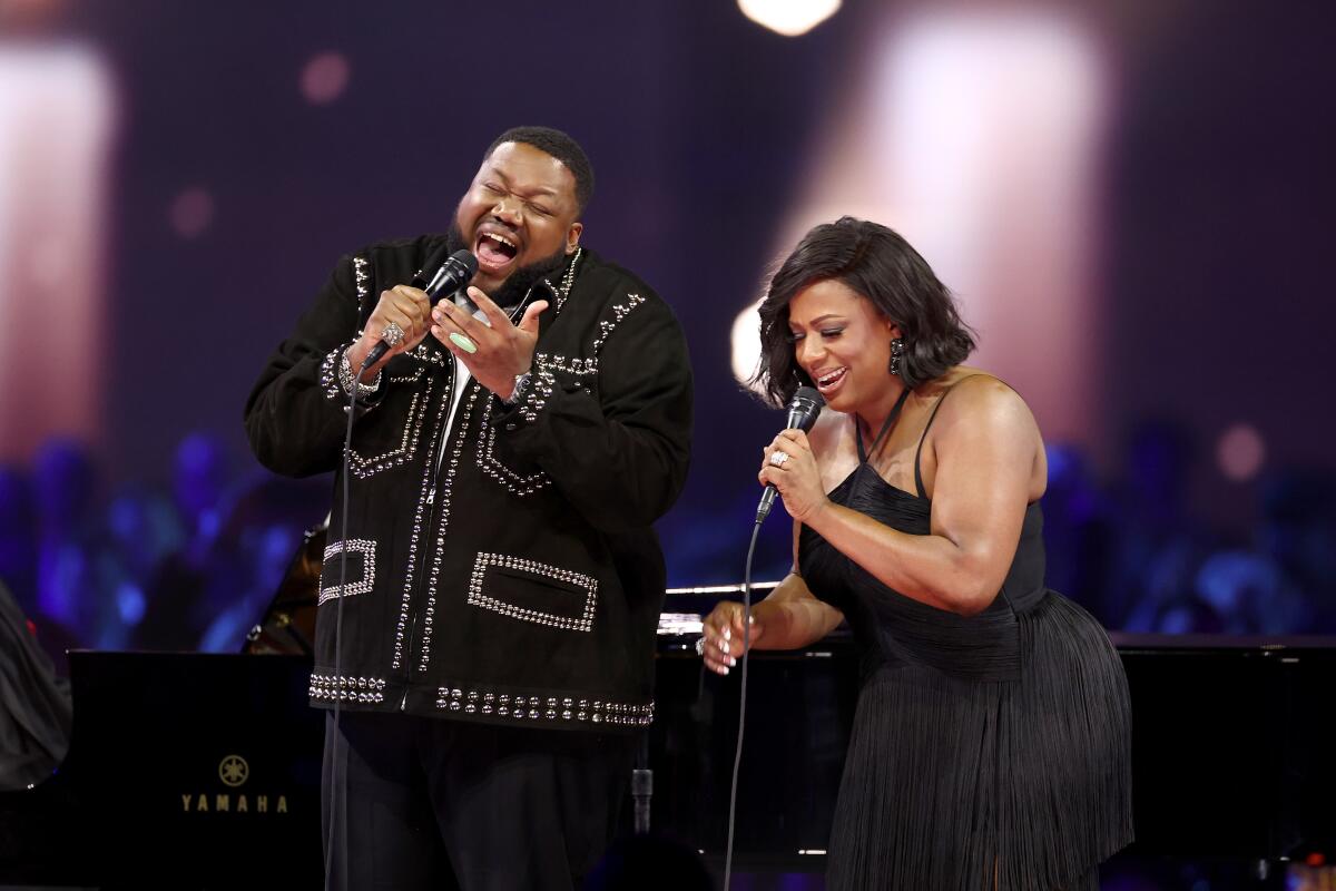 Michael Trotter Jr. and Tanya Trotter of the War on Treaty sing into their microphones on stage. 