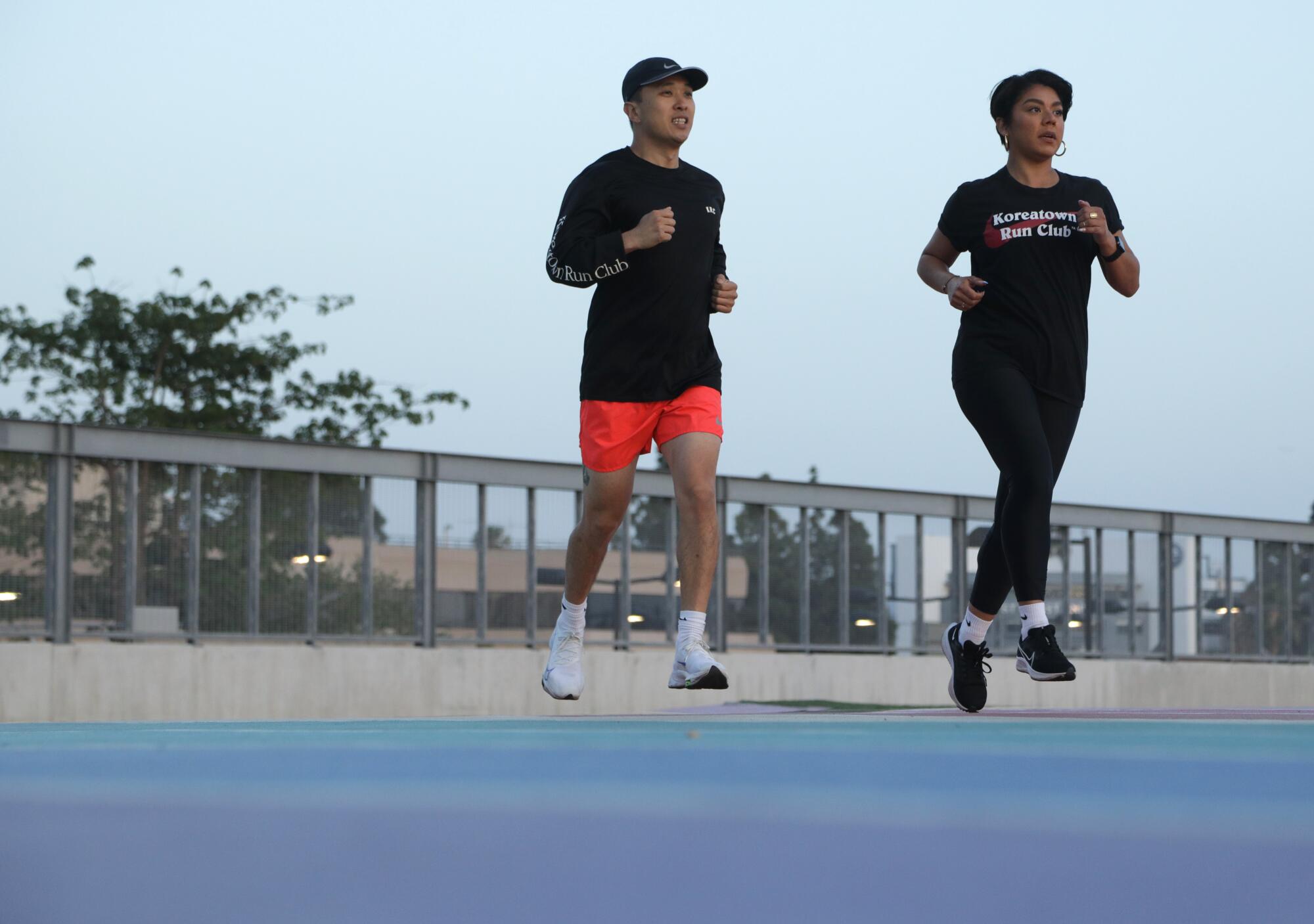 A man and a woman, members of a run club, go jogging.
