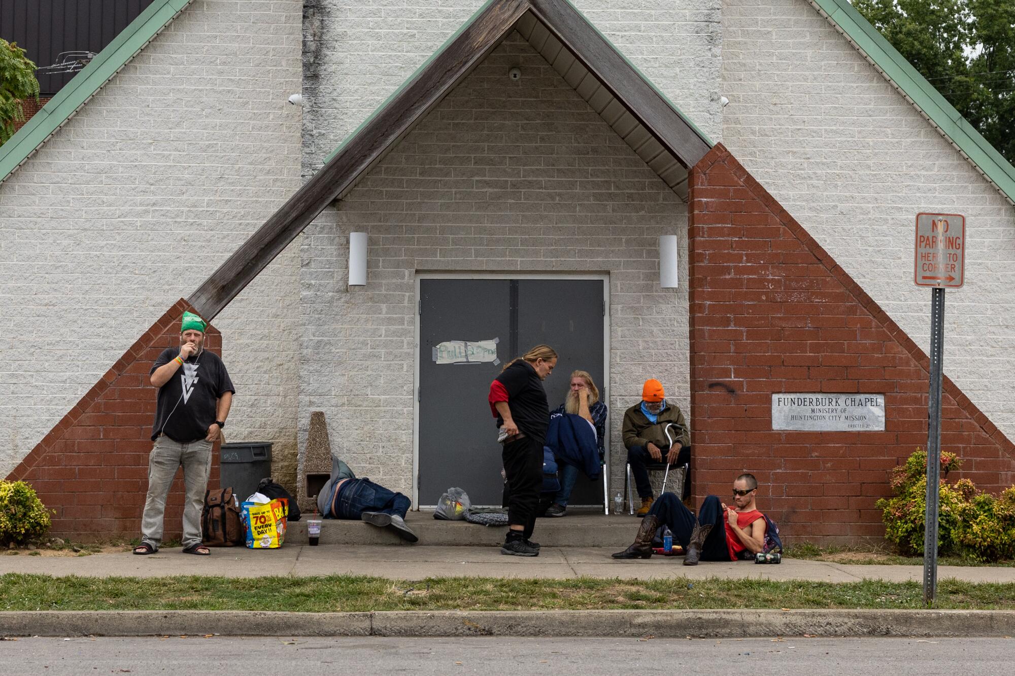 People who are unhoused hang outside the Huntington City Mission's chapel.