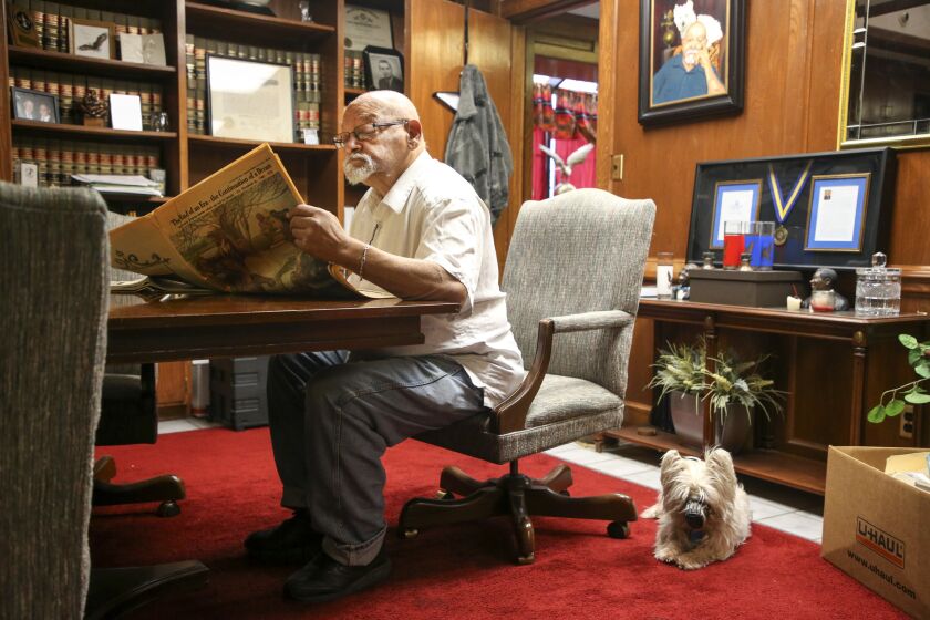 Oklahoma Eagle Executive Editor Jim Goodwin, reads an old newspaper while Annie, Goodwin's West Highland Terrier, lays besides him in a conference room at The Oklahoma Eagle in Tulsa, Okla. on Monday, March 16, 2020. IAN MAULE/Tulsa World