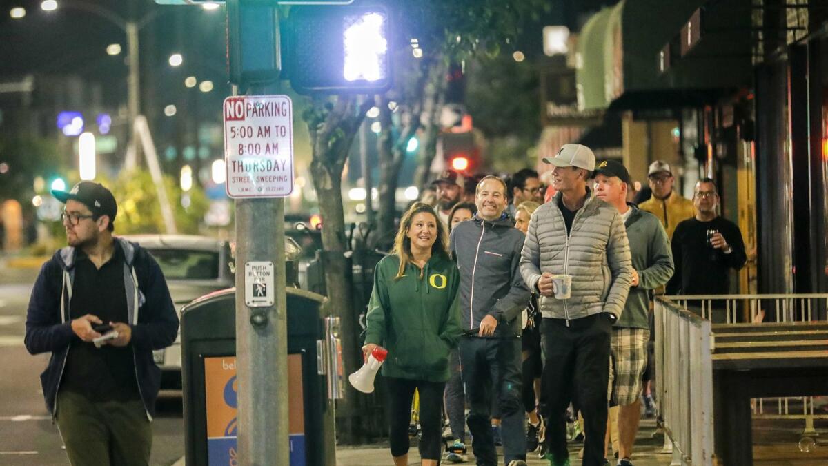 A group of Long Beach residents frustrated by crime that they believe stems from homeless encampments goes on a predawn march through the streets of the Belmont Shore neighborhood.