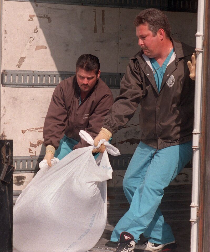 Workers from the Medical Examiner's Office unload a body from a forklift to a refrigerated semi-trailer at the agency's Kearny Mesa office on March 27, 1997, the day after the Heaven's Gate mass suicide was discovered in Rancho Santa Fe.