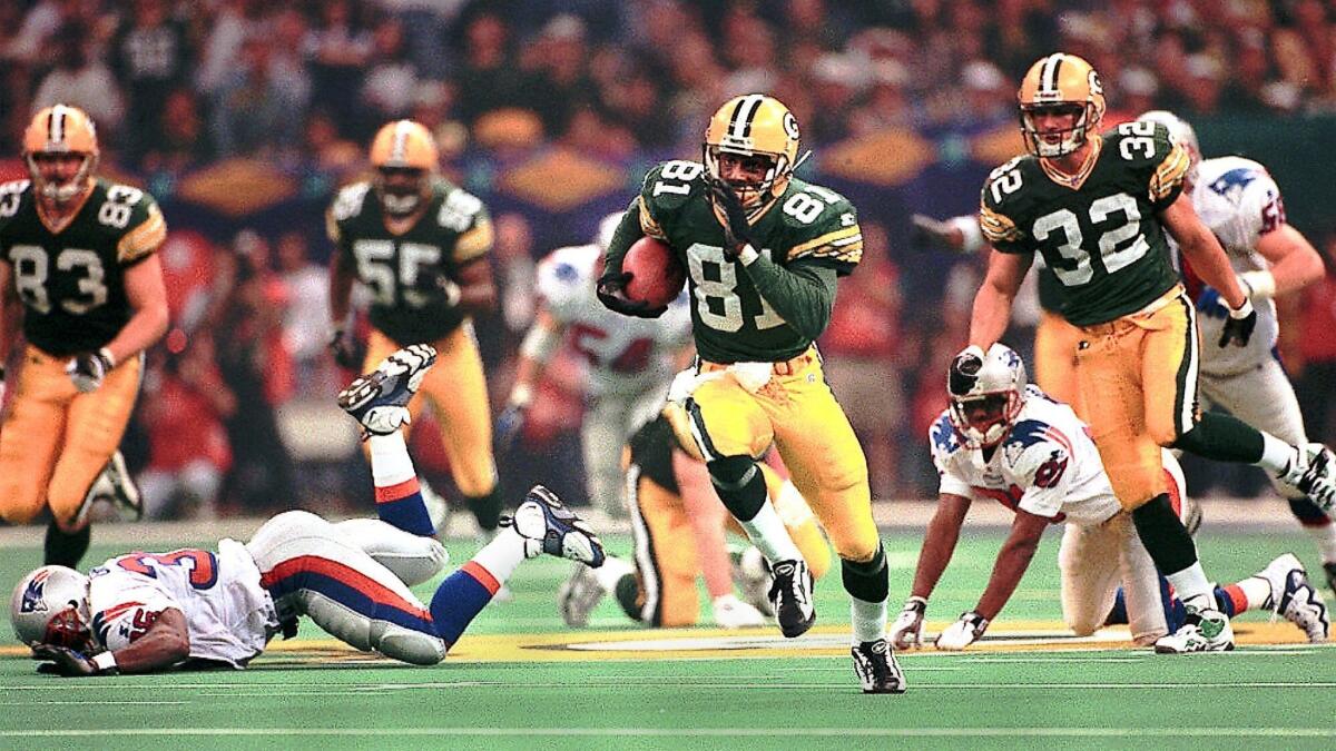 Packers kick returner Desmond Howard (81) leaves Patriots defenders behind as he runs a kickoff back 99 yards for a touchdown during third-quarter action in Super Bowl XXXI.
