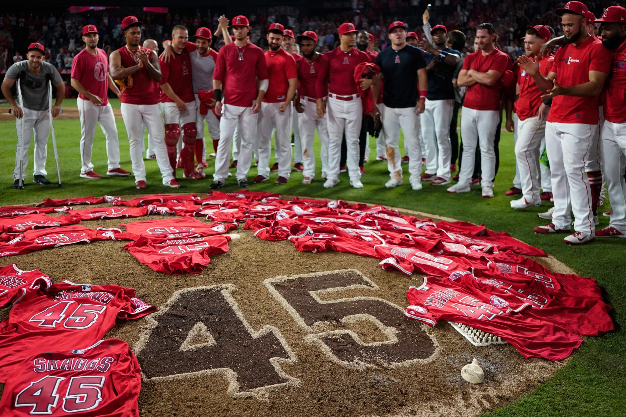 Angels players put jerseys for teammate Tyler Skaggs on the pitcher's mound.