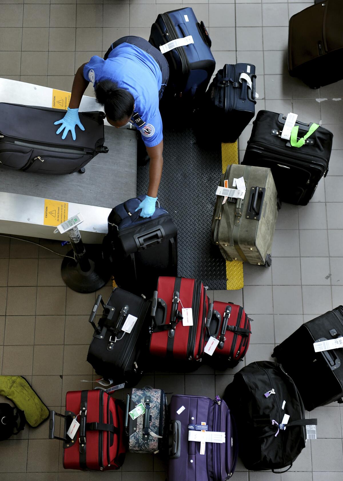 Wally Skalij Los Angeles Times TSA agent Laneisha Howard loads luggag
