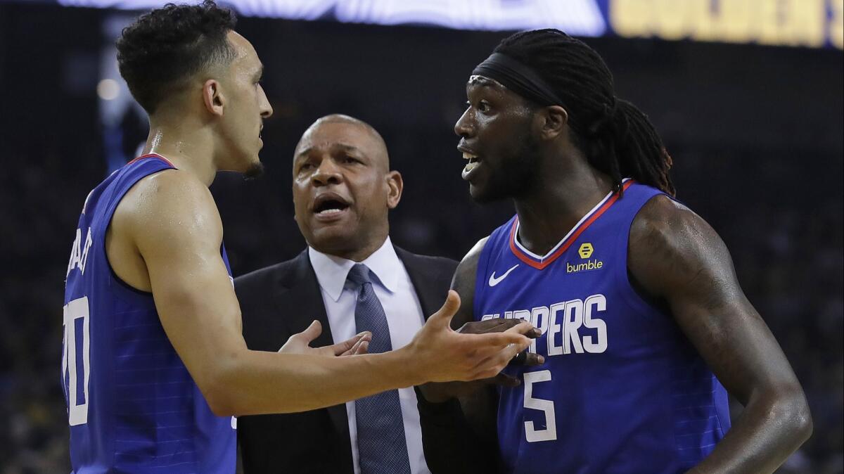 Clippers coach Doc Rivers, center, guard Landry Shamet, left, and center Montrezl Harrell have an animated conversation Sunday.