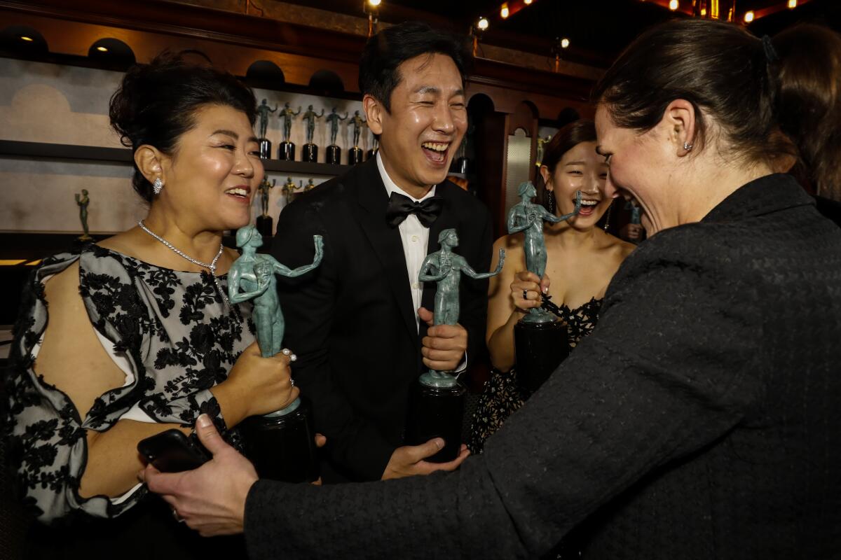 Lee Jung Eun, Lee Sun Kyun and Park So Dam receive their SAG Awards. (Al Seib / Los Angeles Times)