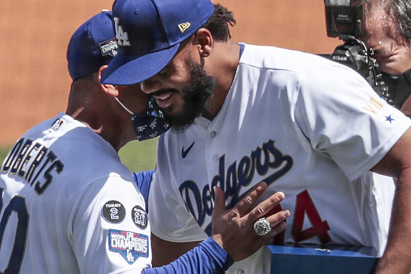 Los Angeles, CA, Friday, April 9, 2021 - Manager Dave Roberts embraces pitcher Kenley Jansen.
