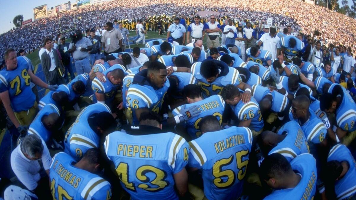 Members of the UCLA Bruins join in prayer after their 1998 victory over the USC Trojans at the Rose Bowl.