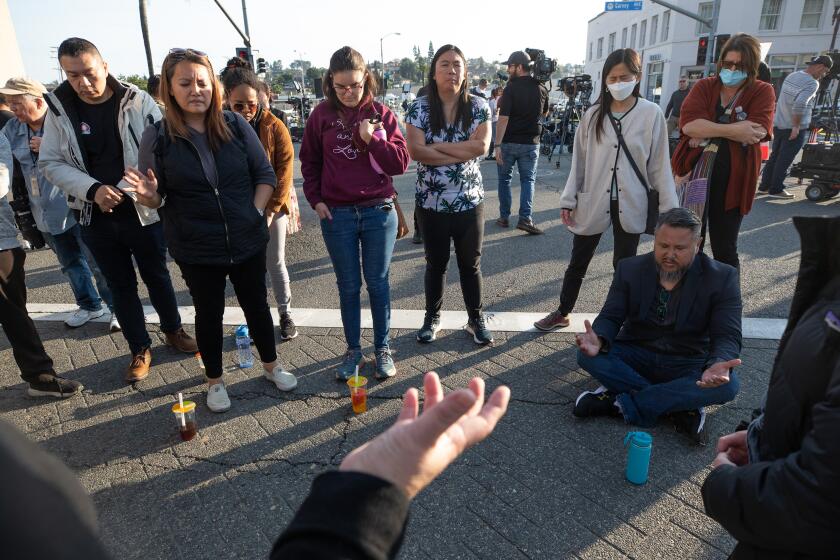 A group of people forming a prayer circle in the street
