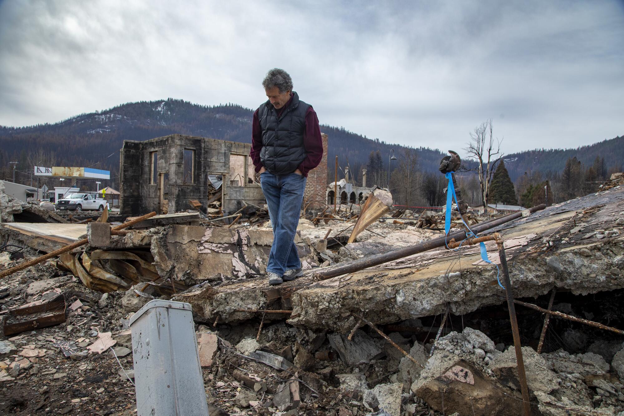 Jonathan Kusel, executive director of the Sierra Institute, stands amid the ruins of the Sierra Lodge in Greenville. 