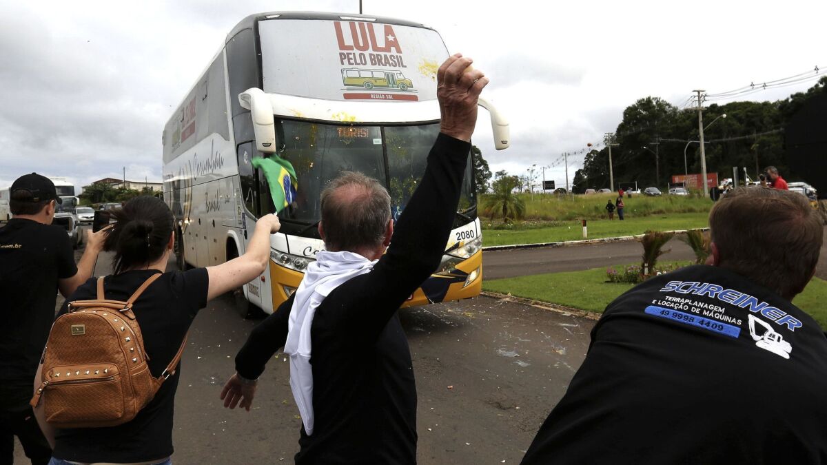Opponents of Brazil's former President Luiz Inacio Lula da Silva throw eggs at his caravan arriving in Sao Miguel do Oeste in southern Brazil, Sunday, March 25, 2018.