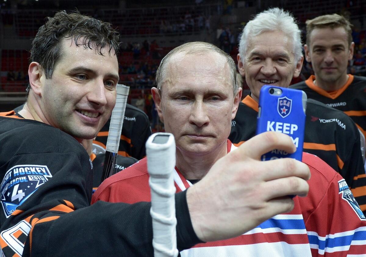 Russian President Vladimir Putin, center, poses for a selfie with SKA hockey club president and KHL board member Roman Rotenberg, left, and businessman Gennady Timchenko, second from right, last May.