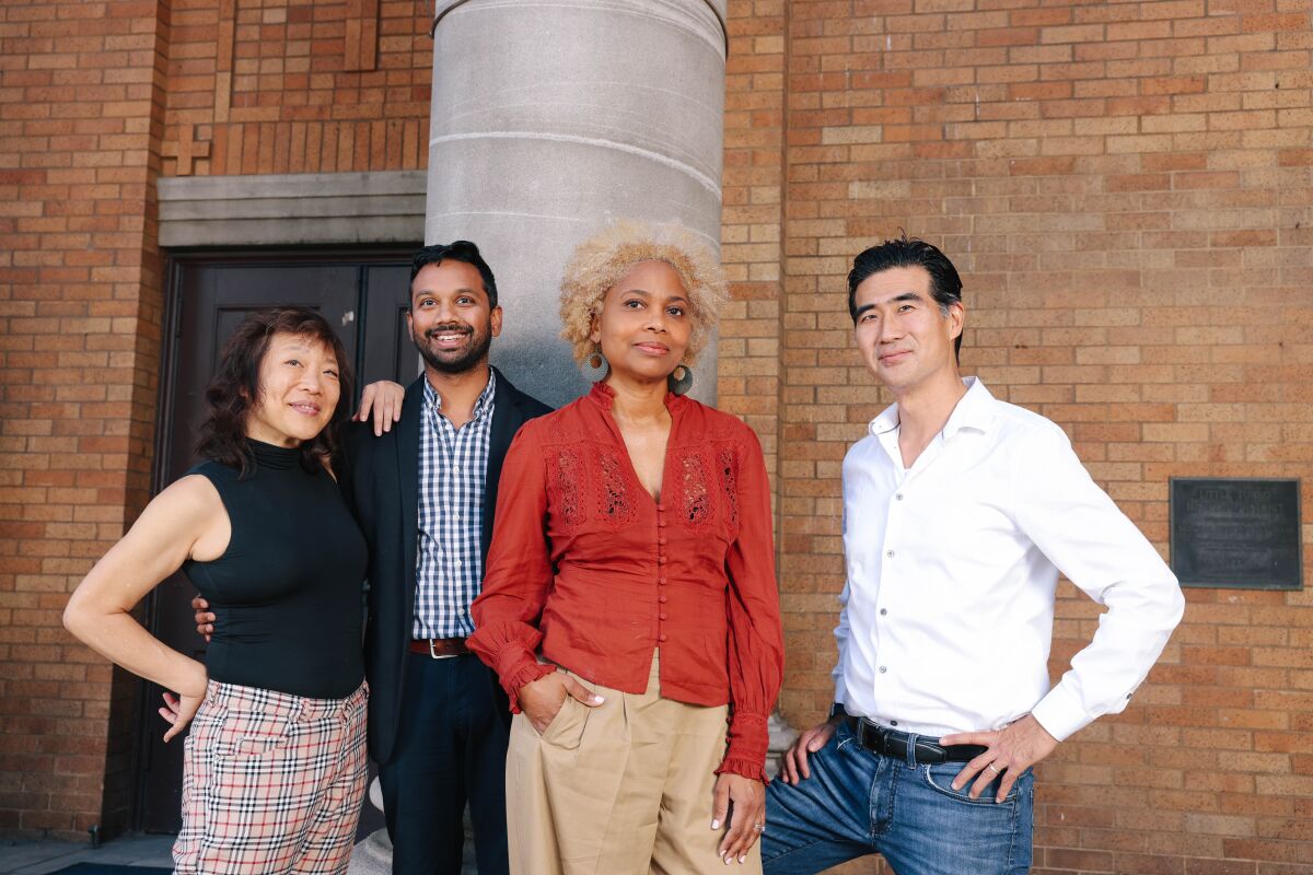 무대 앞에 나란히 서 있는 두 남자와 두 여자.