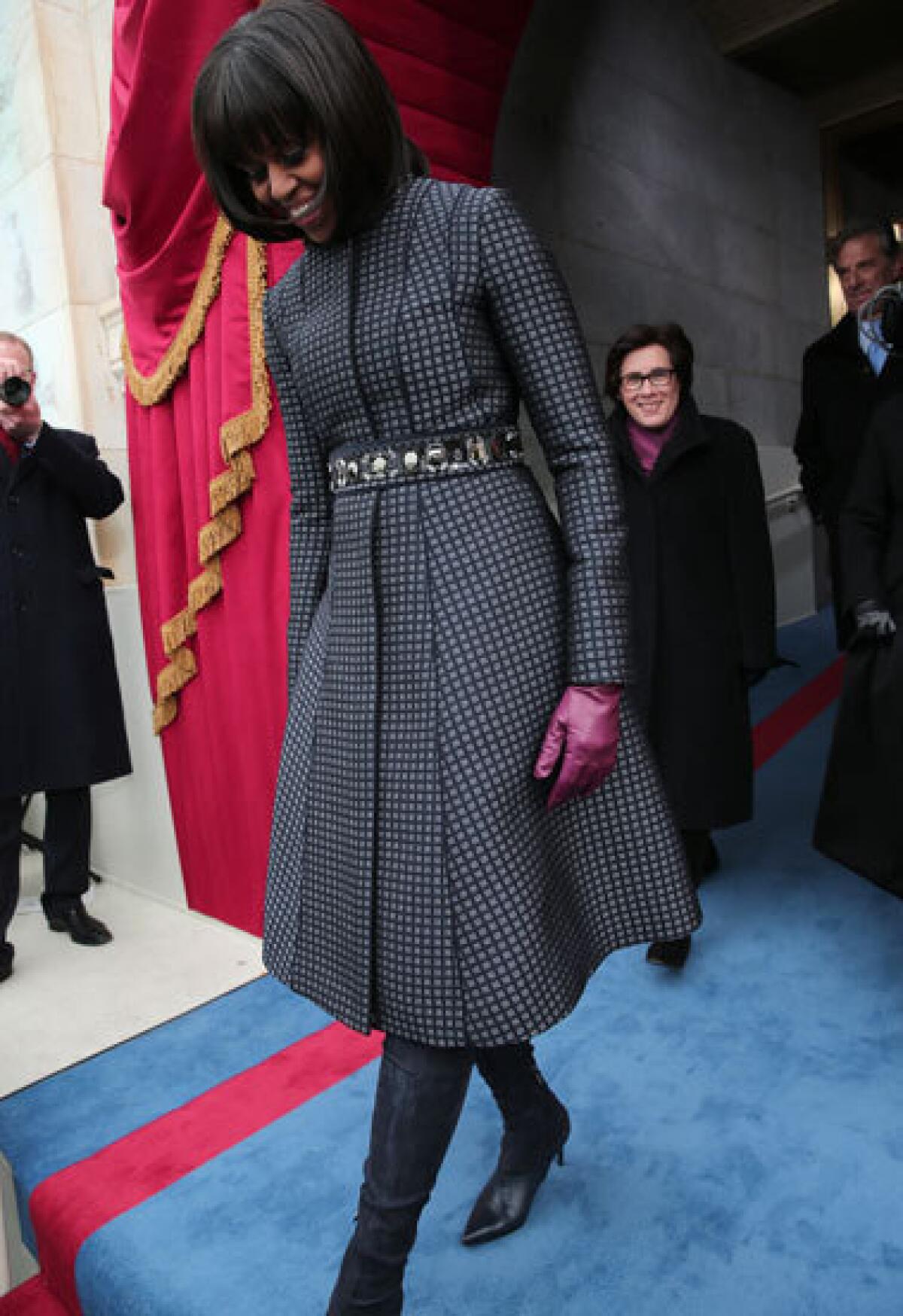 First Lady Michelle Obama arrives during the presidential inauguration wearing a Thom Browne coat.